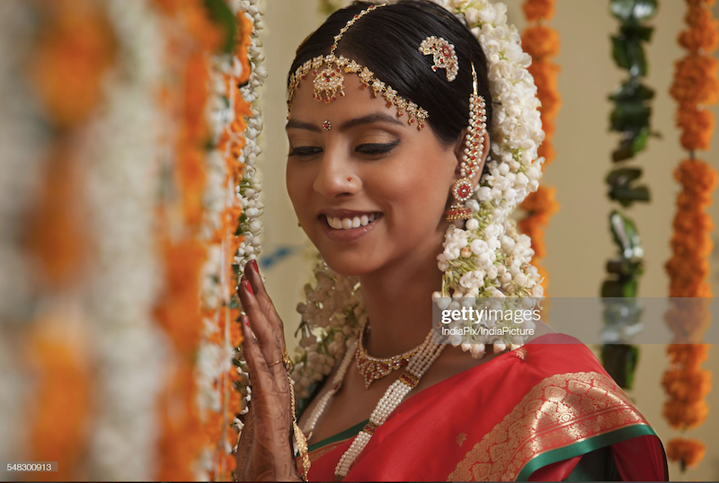 Close-up of bride standing by garlands